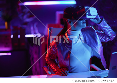 stylish woman in virtual reality goggles in modern office 99664252