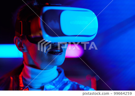 Portrait of trendy 40 years old woman in vr headset on dark 99664259