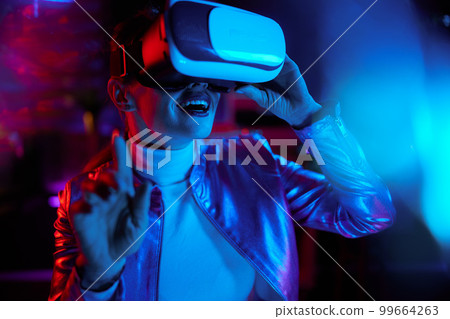 smiling modern woman exploring metaverse in modern office 99664263