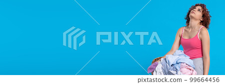 Totally tired girl carries heavy wicker basket with men's shirts. Narrow frame of the photo. Totally tired girl carries heavy wicker basket with men's shirts. Narrow frame of the photo. 99664456