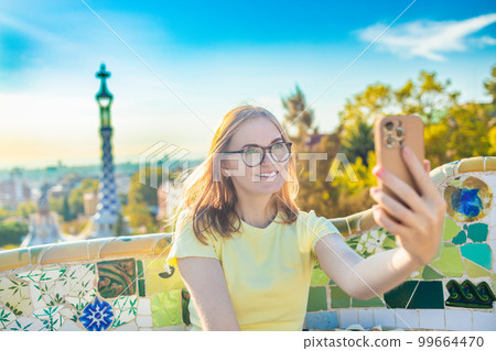 Happy travel woman talking selfie self-portrait with smartphone in Park Guell, Barcelona, Spain.Travel and holidays concept  99664470