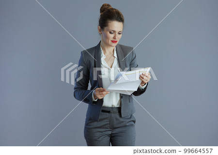 pensive 40 years old woman worker against grey 99664557