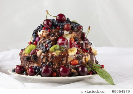 Cake with fruits on a white background. A beautiful fruity dessert. Cake with fruits on a white background. A beautiful fruity dessert. 99664579