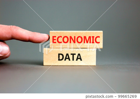 Economic data symbol. Concept words Economic data on wooden block. Beautiful grey table grey background. Businessman hand. Business economic data concept. Copy space. 99665269