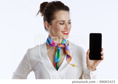 smiling stewardess woman on showing smartphone blank screen 99665423