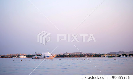 at sunset a small yacht is anchored in a sea bay at sunset a small yacht is anchored in a sea bay 99665596