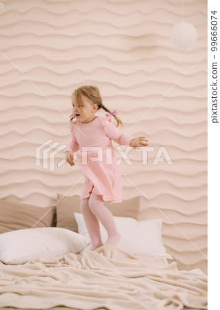 Morning of little girl in a comfortable bedroom. Happy child girl having fun and plays in bed Morning of little girl in a comfortable bedroom. Happy child girl having fun and plays in bed 99666074