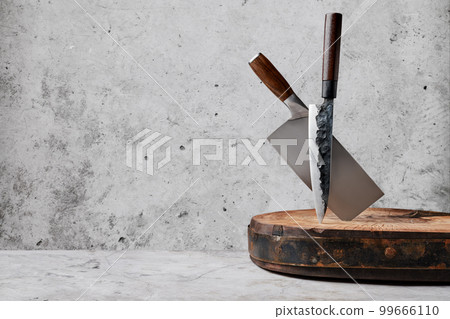 Knive and cleaver sticking out of wooden block 99666110