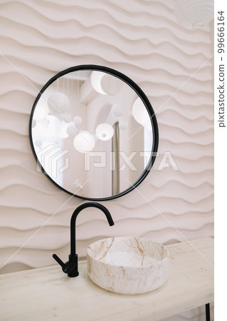 Modern interior with stylish round mirror by beige wall in a cozy room, copy space, elegant accessories in stylish home decor Modern interior with stylish round mirror by beige wall in a cozy room, copy space, elegant accessories in stylish home decor 99666164