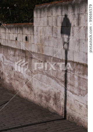 Shadow of a street lamp on a white wall Shadow of a street lamp on a white wall 99666579
