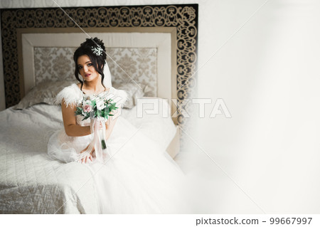 Bride holding big and beautiful wedding bouquet with flowers Bride holding big and beautiful wedding bouquet with flowers 99667997