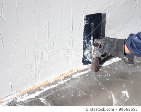 A trowel is being applied to prevent the spalling of a concrete structure A trowel is being applied to prevent the spalling of a concrete structure 99668653