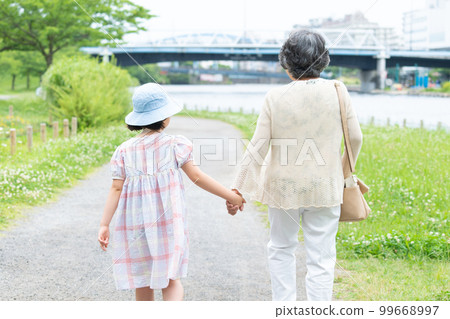 girl and grandma walking hand in hand girl and grandma walking hand in hand 99668997