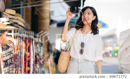 Portrait young beautiful woman with camera explore street in Bangkok, Thailand 99671772