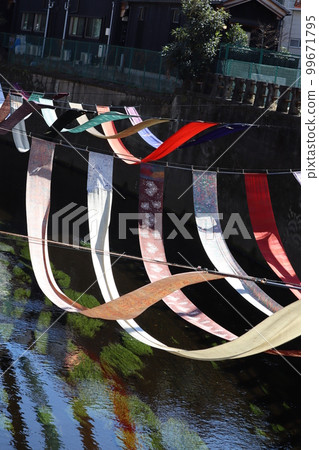 On the dyeing path, the dyed goods displayed along the river are in a gentle breeze. On the dyeing path, the dyed goods displayed along the river are in a gentle breeze. 99671795