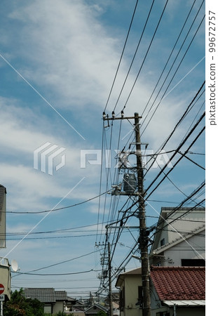 Various cables and wires and utility poles that support them 99672757