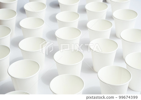 Several disposable white paper cups. Mock up to go coffee cups with shadows on white. Several disposable white paper cups. Mock up to go coffee cups with shadows on white. 99674399