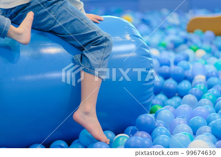Child's feet playing in ball pool Child's feet playing in ball pool 99674630