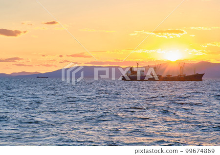Fishing ships are in the roadstead at sunset. 99674869