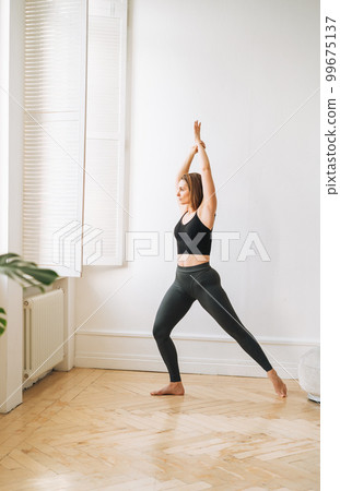 Young slim woman in sportwear doing fitness exercises, girl dancing at bright studio Young slim woman in sportwear doing fitness exercises, girl dancing at bright studio 99675137