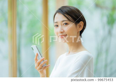 Woman in the living room Smartphone Woman in the living room Smartphone 99675453