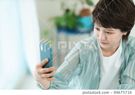 操作智能手機的一個少婦 操作智能手機的一個少婦 99675716