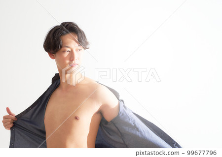 一個脫掉襯衫，露出裸露皮膚的年輕人 男士美容生活方式形象 99677796