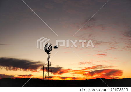 The silhouette of a windmill standing in the wilderness The silhouette of a windmill standing in the wilderness 99678893