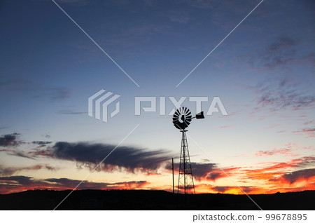The silhouette of a windmill standing alone in the wilderness The silhouette of a windmill standing alone in the wilderness 99678895
