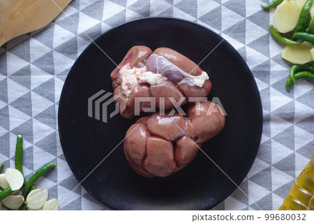 Raw fresh lamb kidneys on a chopping board  99680032