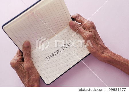 senior women's hand holding thank you note , top down  99681377