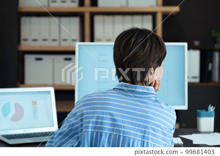 在辦公室工作的年輕女性的後視圖 99681403