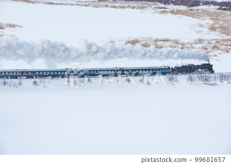Retro steam train moves at winter day. 99681657