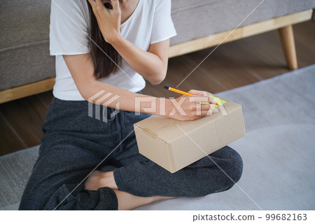 Business From Home Asian woman preparing package delivery box Shipping for shopping online. young start up small business owner at home online order Business From Home Asian woman preparing package delivery box Shipping for shopping online. young start up small business owner at home online order 99682163