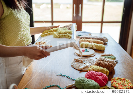Punch needle. Asian Woman making handmade Hobby knitting in studio workshop. designer workplace Handmade craft project DIY embroidery concept. 99682171