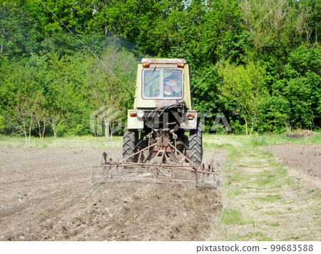 Plowed field by tractor in brown soil on open countryside nature Plowed field by tractor in brown soil on open countryside nature 99683588