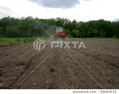 Plowed field by tractor in brown soil on open countryside nature Plowed field by tractor in brown soil on open countryside nature 99683619