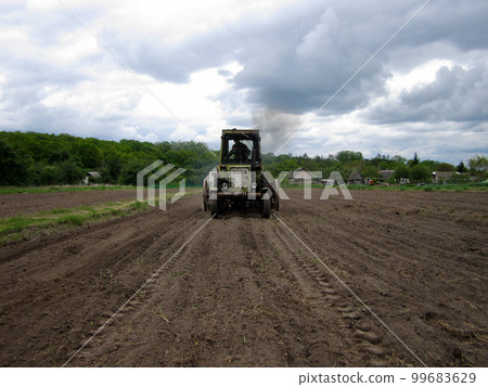 Plowed field by tractor in brown soil on open countryside nature 99683629