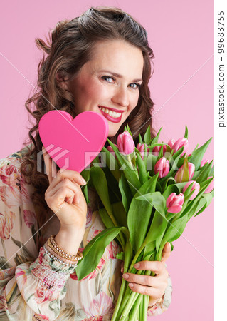 smiling elegant woman in floral dress on pink smiling elegant woman in floral dress on pink 99683755