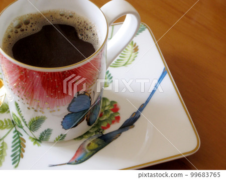 Beauty coffeecup standing on wooden table with dark tasty coffee Beauty coffeecup standing on wooden table with dark tasty coffee 99683765