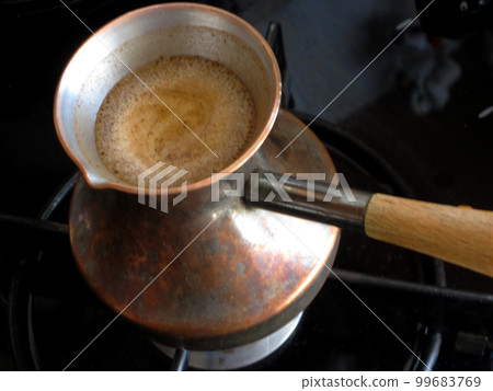 Barista preparing hot tasty drink from copper turk 99683769