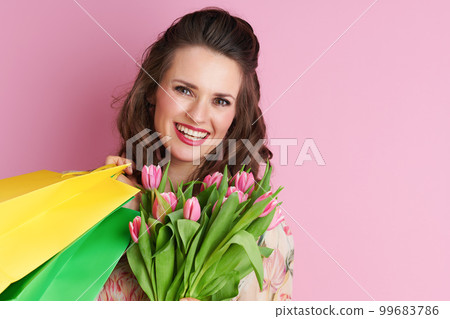 Portrait of smiling stylish woman in floral dress on pink Portrait of smiling stylish woman in floral dress on pink 99683786