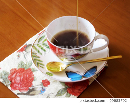 Beauty coffeecup standing on wooden table with dark tasty coffee Beauty coffeecup standing on wooden table with dark tasty coffee 99683792