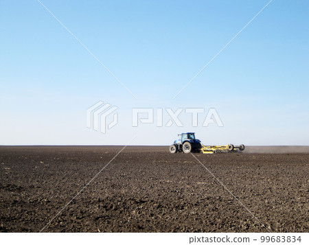 Plowed field by tractor in brown soil on open countryside nature 99683834