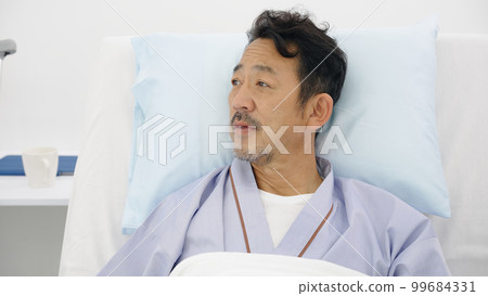 Hospitalized patient looking outside in sickbed 99684331