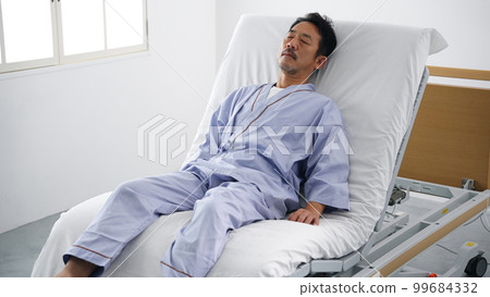 Man sleeping on an electric reclining bed 99684332