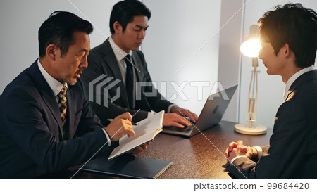 Group talking in a dark room Interrogation Detective 99684420