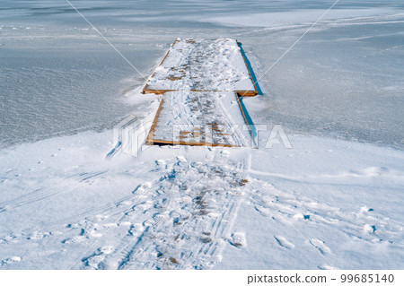 Winter landscape of wooden dock on frozen lake 99685140