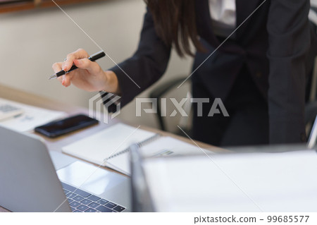 Work of secretary concept, Female secretary reading data on laptop and taking notes in notebook 99685577
