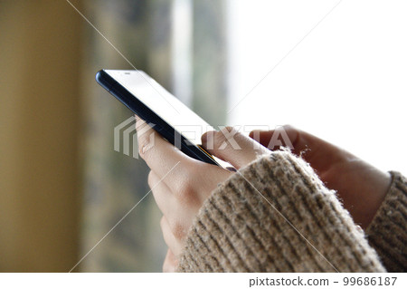 拍攝一名操作智能手機的二十多歲女性的手 99686187